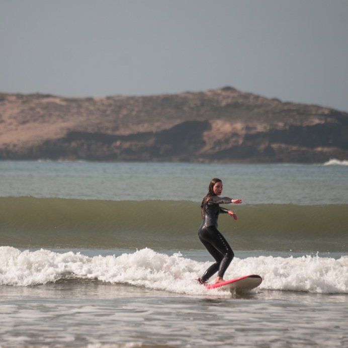 Surfer in perfect pose riding a green wave in Essaouira, Morocco after private surf lesson
