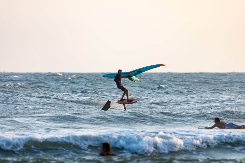Exciting wingfoiling experience on ocean waves with active surfers enjoying the sport.