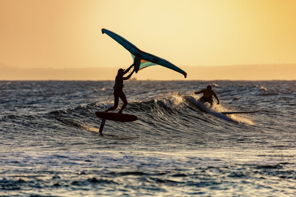 Exhilarating scene of surfers riding the ocean waves at sunset, capturing the thrill of water sports.
