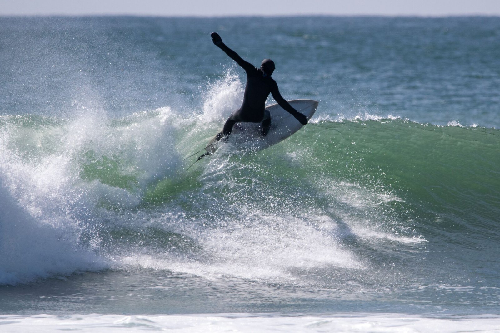 A surfer rides a powerful wave in South Kingstown, RI, showcasing their skill and the ocean's beauty.