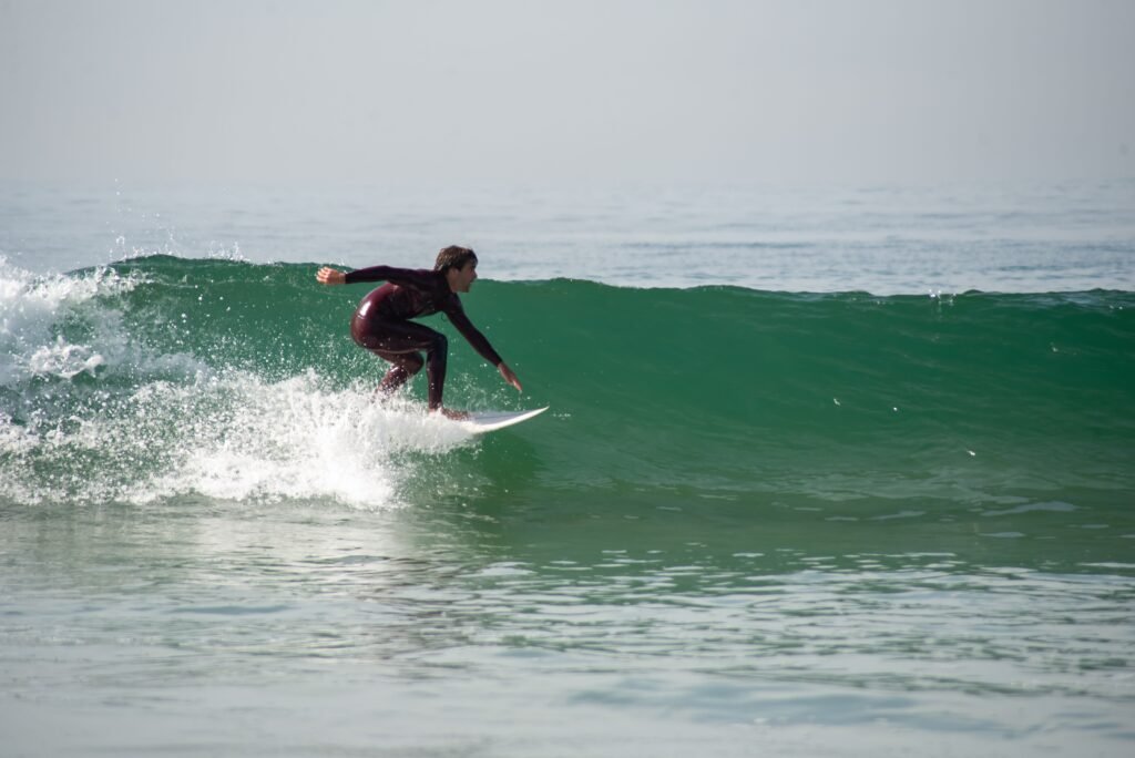 A surfer enjoying a perfect wave on a sunny day at a Portuguese beach.